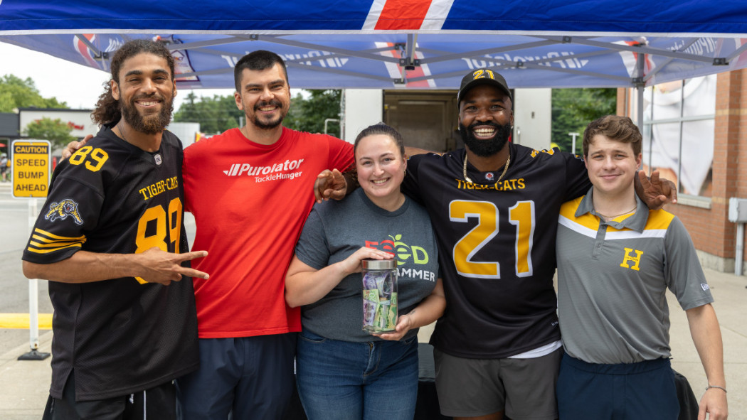 Purolator, Hamilton Tiger-Cats, and Hamilton Food Share representatives during a Stuff-a-Truck event in for Purolator Tackle Hunger 2025.  