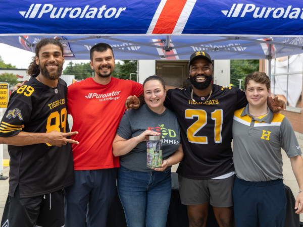 Purolator, Hamilton Tiger-Cats, and Hamilton Food Share representatives during a Stuff-a-Truck event in for Purolator Tackle Hunger 2025.  